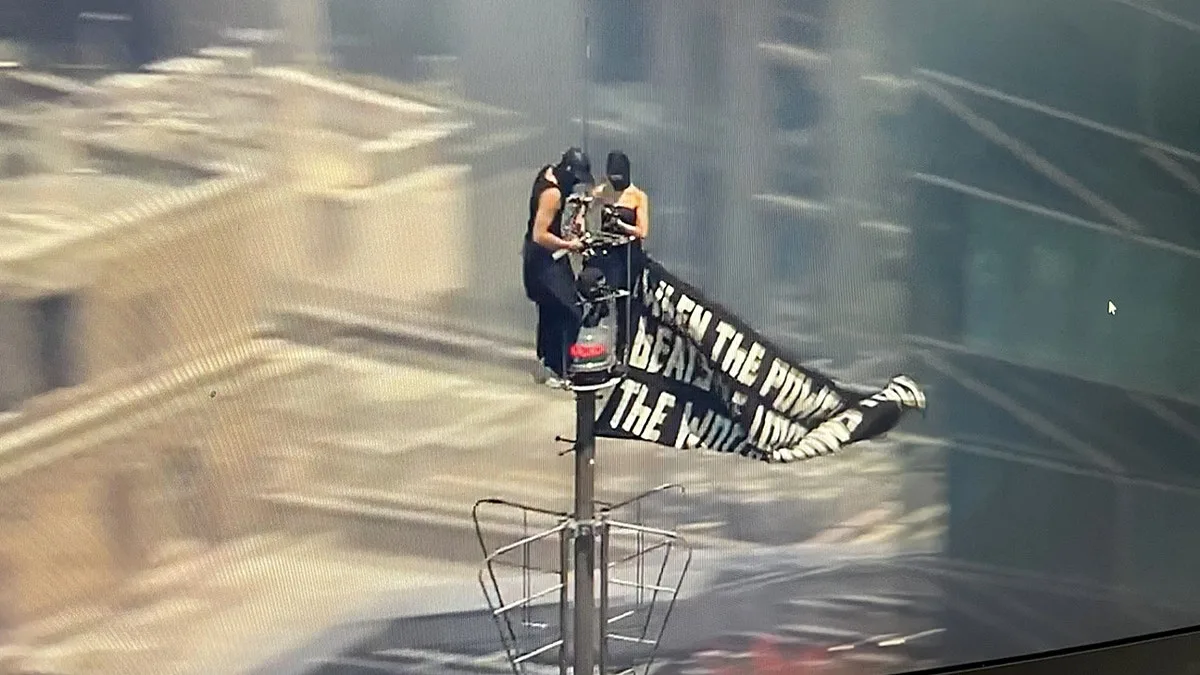 Two Individuals Scale Empire State Building, Unfurl Banner with Message